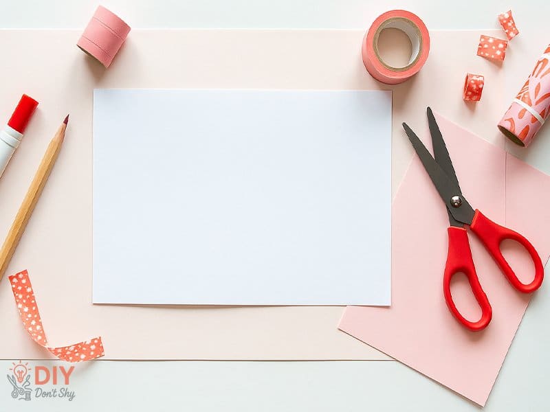 Basic craft supplies for making homemade Valentine cards for him including scissors, glue, and paper