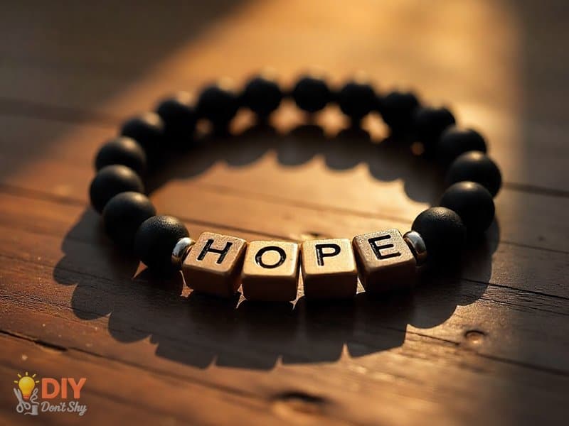 Minimalist black beaded word bracelet with metallic spacers spelling HOPE.