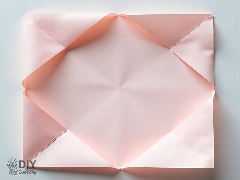 Folding all corners of paper into the center to form the base of a paper box.