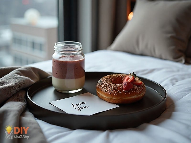 Romantic breakfast in bed with smoothie, bagel, and love note as a surprise gift for wife.