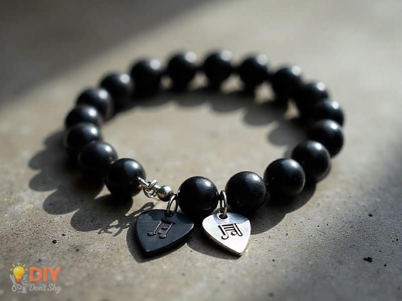 Black beaded bracelet with silver music note charms and a guitar pick charm.
