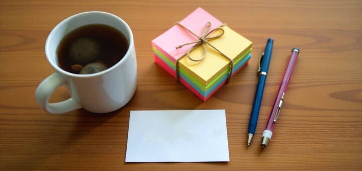 Neatly arranged last-minute teacher gifts with coffee mug, sticky notes, and thank-you card on wooden desk.
