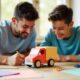 Father and son making a colorful paper truck together using paper, glue, and scissors during a fun DIY craft project.