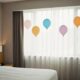 Hotel room birthday decoration with balloons, banner, and soft lighting