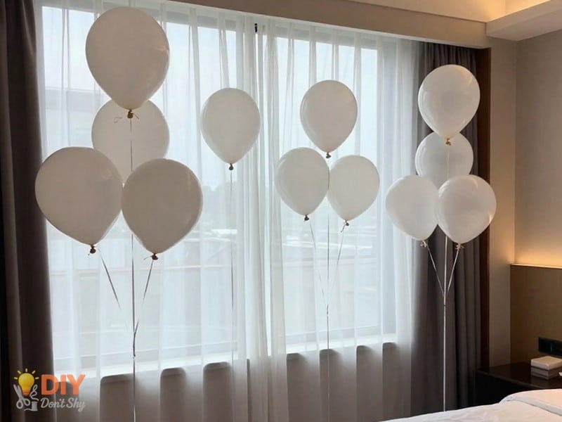 Colorful celebration visual showing place balloons in clusters for a lively hotel room birthday look.