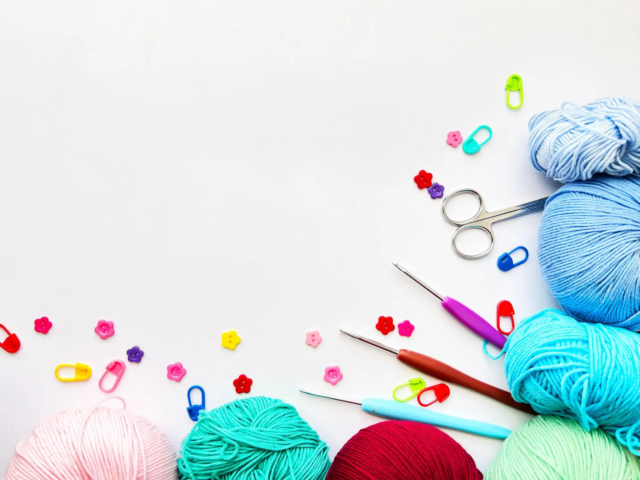 Essential crochet tools including yarn, hooks, scissors, and needle for beginners